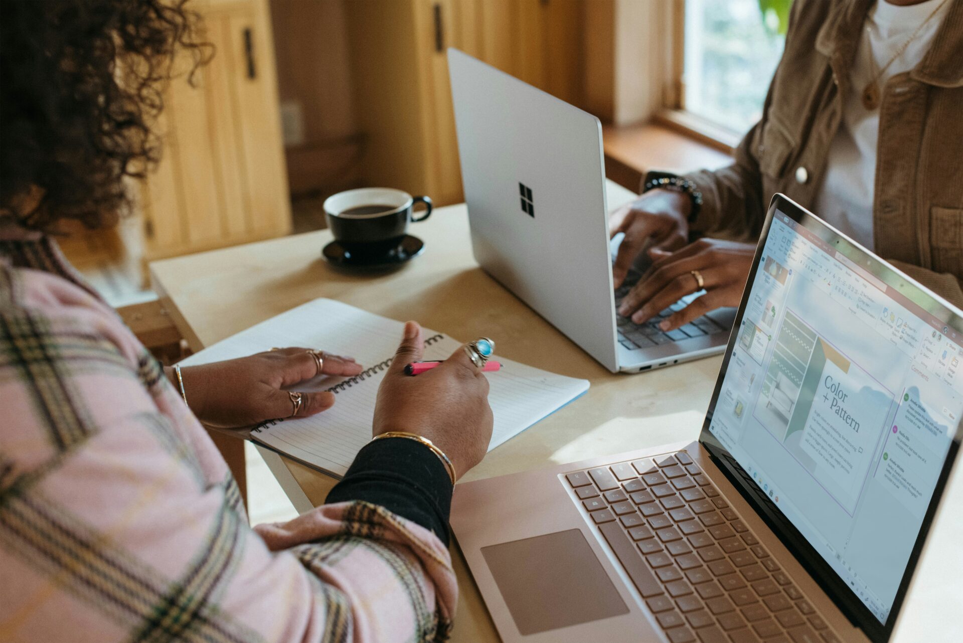 Two colleagues work on their laptops opposite each other.